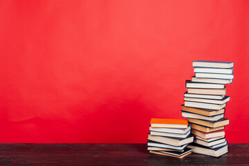 many stacks of educational books for exams in the library on a red background