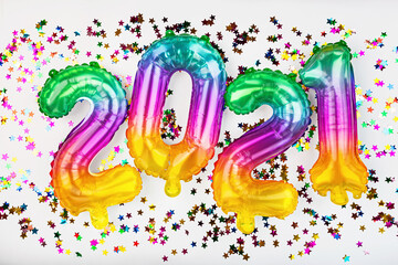Happy new year 2021 background. Metallic balloons rainbow colors on white. Flat lay, top view, mockup, overhead. Winter holiday celebration