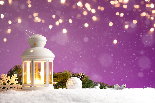 Christmas lantern with decorations on purple background with golden lights