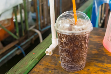 aerated soft drink with ice in plastic glass
