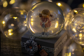 decorative snow globe with a girl angel on a dark wooden background