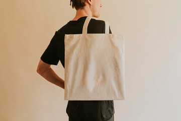 Back view man carrying tote bag - obrazy, fototapety, plakaty