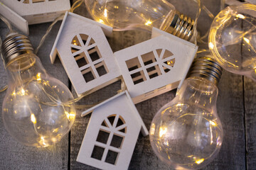 decorative Christmas garland in the form of wooden houses and light bulbs