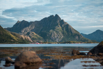 view of a massive mountain above a peaceful lake and some small red houses