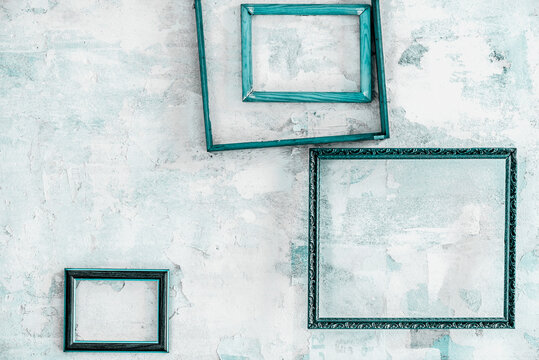 Various blue frames on a peeled plaster wall