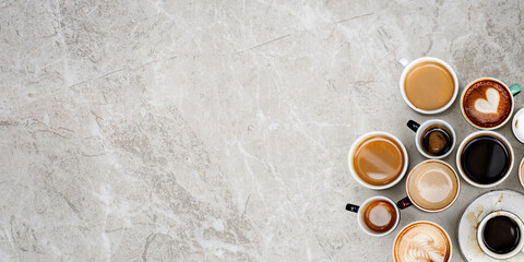 Assorted coffee cups on a marble textured background