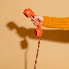 Woman answering a corded retro phone - obrazy, fototapety, plakaty