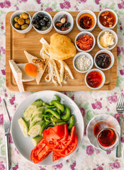 Top flatlay view of a traditional Turkish meal with strong tea, vegetables and other snacks and pickles for a rich middle eastern breakfast in the outdoor restaurant