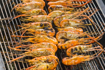 Closeup delicious prawns on charcoal grilled on fire.
