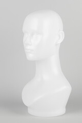 White mannequin head in profile on a gray background