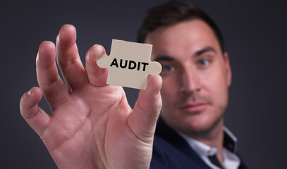 Business, Technology, Internet and network concept. Young businessman shows the word: Audit