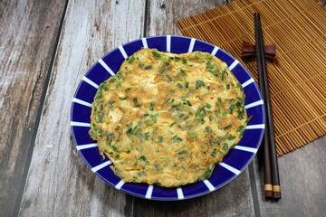 Deep fried mixed egg with cutting spring onion on the plate. Famous traditional comfort menu in the morning. 