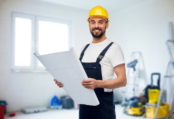 repair, construction and building concept - happy smiling male worker or builder in helmet with blueprint over room with equipment on background
