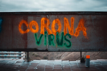 Naklejka premium Corona virus sing write with a bright fluorescent can paint orange and green