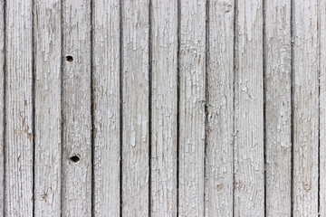 The surface of old wooden boards with peeling and weathered paint.