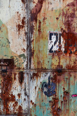 Rusty abstract wall. Background with cracks and green paint. Orange green vintage metal wall with number