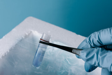 Cryopreservation of sample in laboratory. Scientist hold test tube. A liquid nitrogen bank...