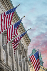 American Flags hanging from a old city building at sunset