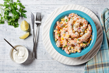 Shrimp salad with corn on a blue plate, close-up