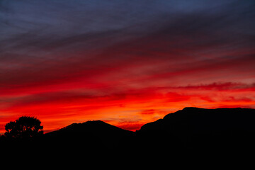 Stylish autumn red sunset sky over the mountains. Sunset background in crimson shades for the website and photoshop.