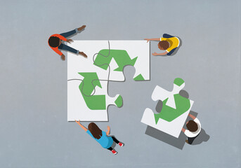 Team finishing recycling symbol jigsaw puzzle with missing piece

