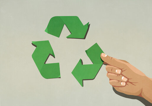 Hand assembling green recycling symbol arrows
