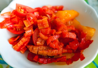 Cut red bell pepper on a white plate closeup