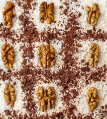 Cake decorated with cocoa and walnuts closeup
