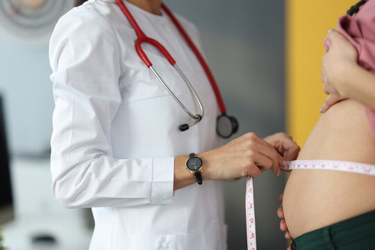 Doctor measures belly of pregnant woman. Reception of pregnant women at the gynecologist concept