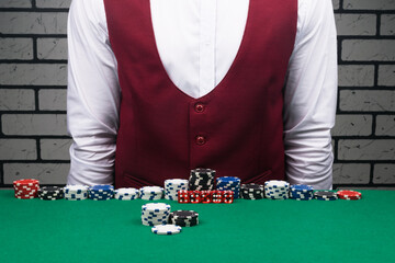 the croupier stands at a table with poker chips