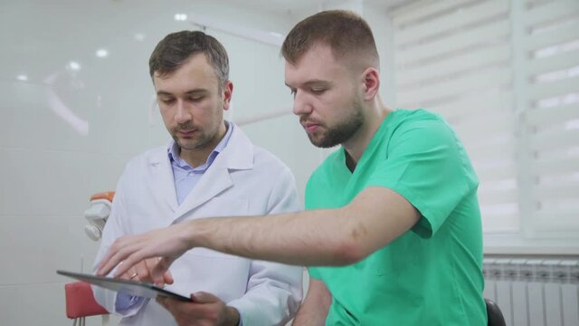 Two doctors discussing a pacient case at dental cabinet