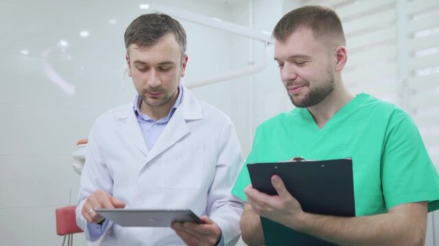 Two doctors discussing a pacient case at dental cabinet