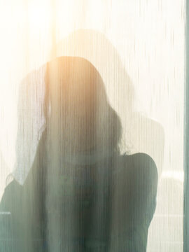 A Woman Shadow Behind A White Curtain