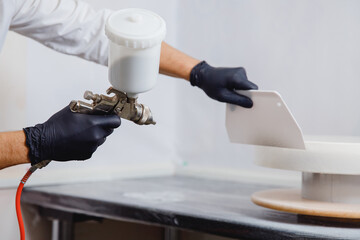 Applies hot chocolate painting to surface of cake with spray gun pastry chef