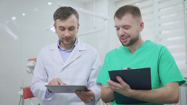 Two doctors discussing a pacient case at dental cabinet