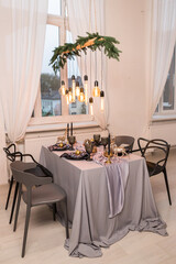 Side view of festive Christmas table setting with empty wine glasses and black plate