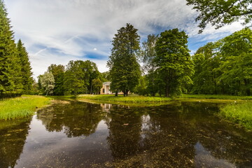 Fototapeta na wymiar Summer landscape in a city Park with trees, grass, river, sky with clouds