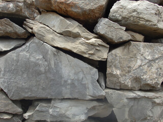 Background from rock texture close-up. The wall of natural stone of gray and brown.