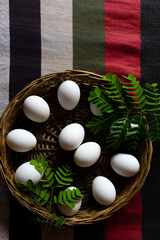 White eggs stacked in a basket