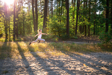 Preteen girl gymnast running and jumping in forest: wellness, freedom, future