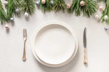 Christmas table setting with white holiday elegant decorations on white table. View from above.