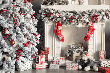 Beautiful fireplace decorated for Christmas with red socks and snow garland