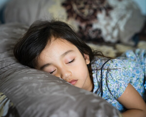 Daytime sleeping time of a toddler child. Little girl sleeping on the bed.