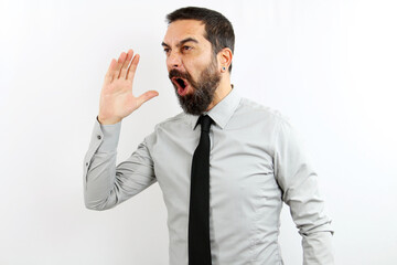 A bearded businessman, on isolated white background, yells and yells loud with his hand next to his mouth. Business concept