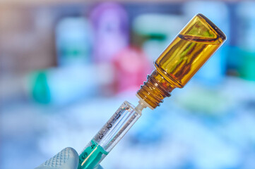 Close up of a syringe with vaccine. Flask with vaccine. Coronavirus vaccine in a syringe. Vial with vaccine. Extracting vaccine from a vial with a syringe. Biontech vaccine. Moderna vaccine.