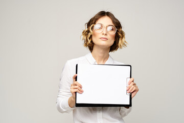 Naklejka premium Business woman with a folder of documents on a light background cropped view and shirt suit