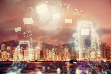 Double exposure of envelop hologram flying from gadget and city view background. Concept e-mail.