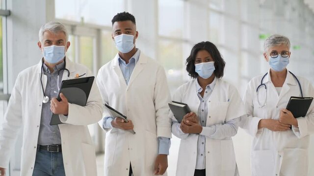 Group of doctors standing in hospital corridor with face mask