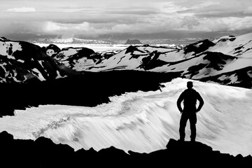 Hiker Man Silhouette enjoying view from Ok Vulcano crater to the snow Mountains of Thorisdalur....