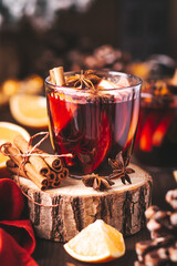 Mulled wine on table with Christmas lights and red napkin, cozy winter still life. Winter lifestyle at home, winter drink closeup, warm atmosphere